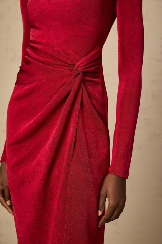 A red midi dress with a high slit and gathered fabric details worn by a model