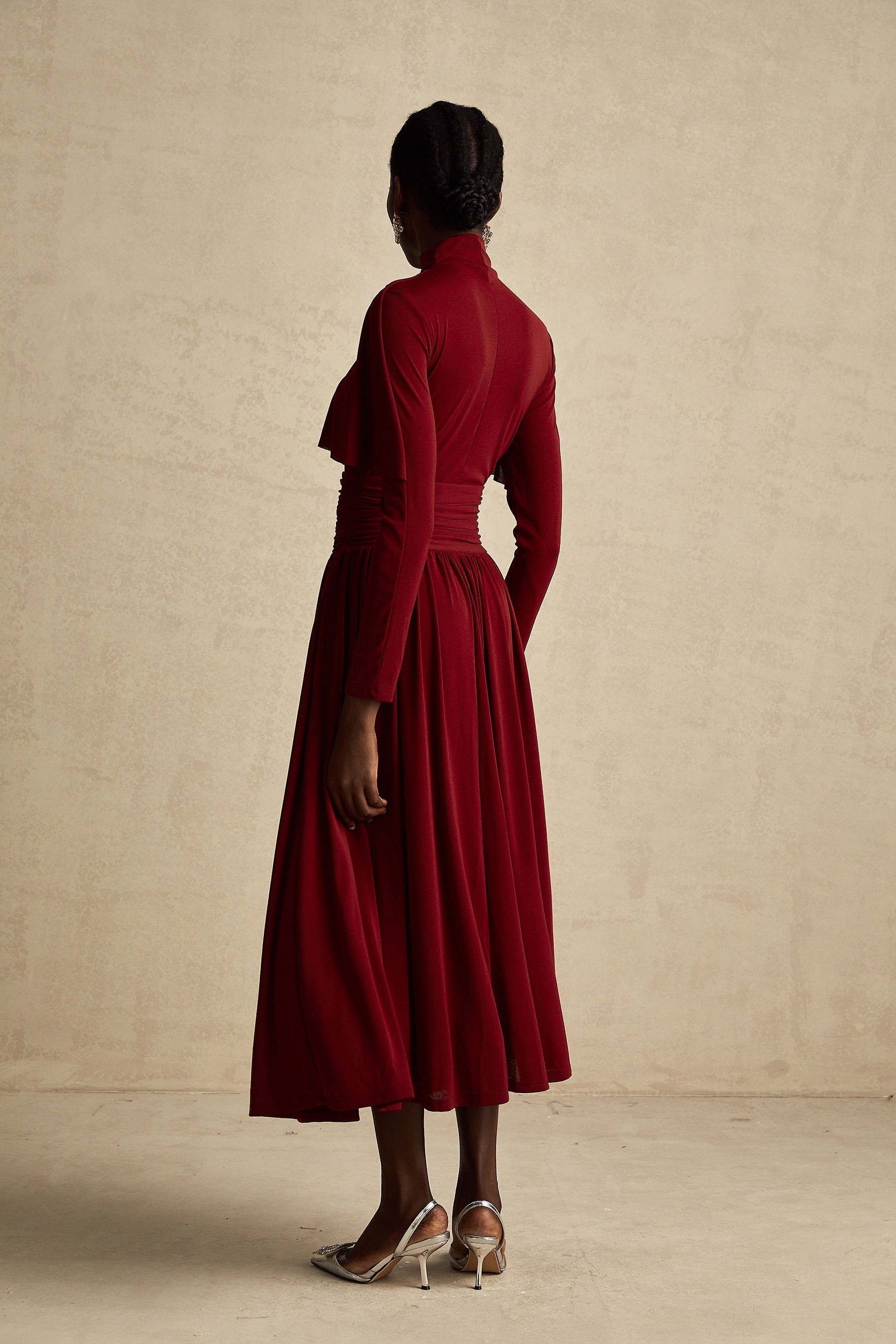 A red midi dress with ruched detailing and a flap design named Camille