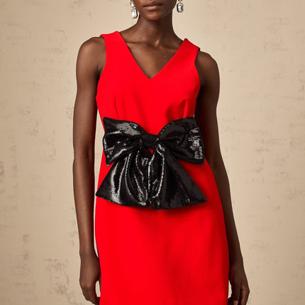A red mini dress with a Vneckline featuring a sequin bow detail on the front