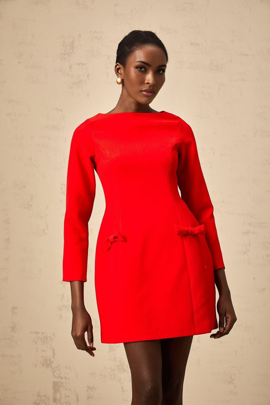 A red mini dress with long sleeves and a prominent bow detail at the neckline