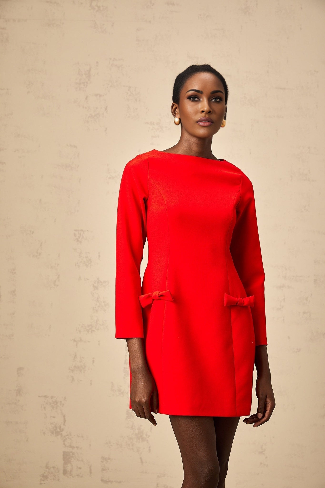 A red mini dress with long sleeves and a prominent bowknot detail