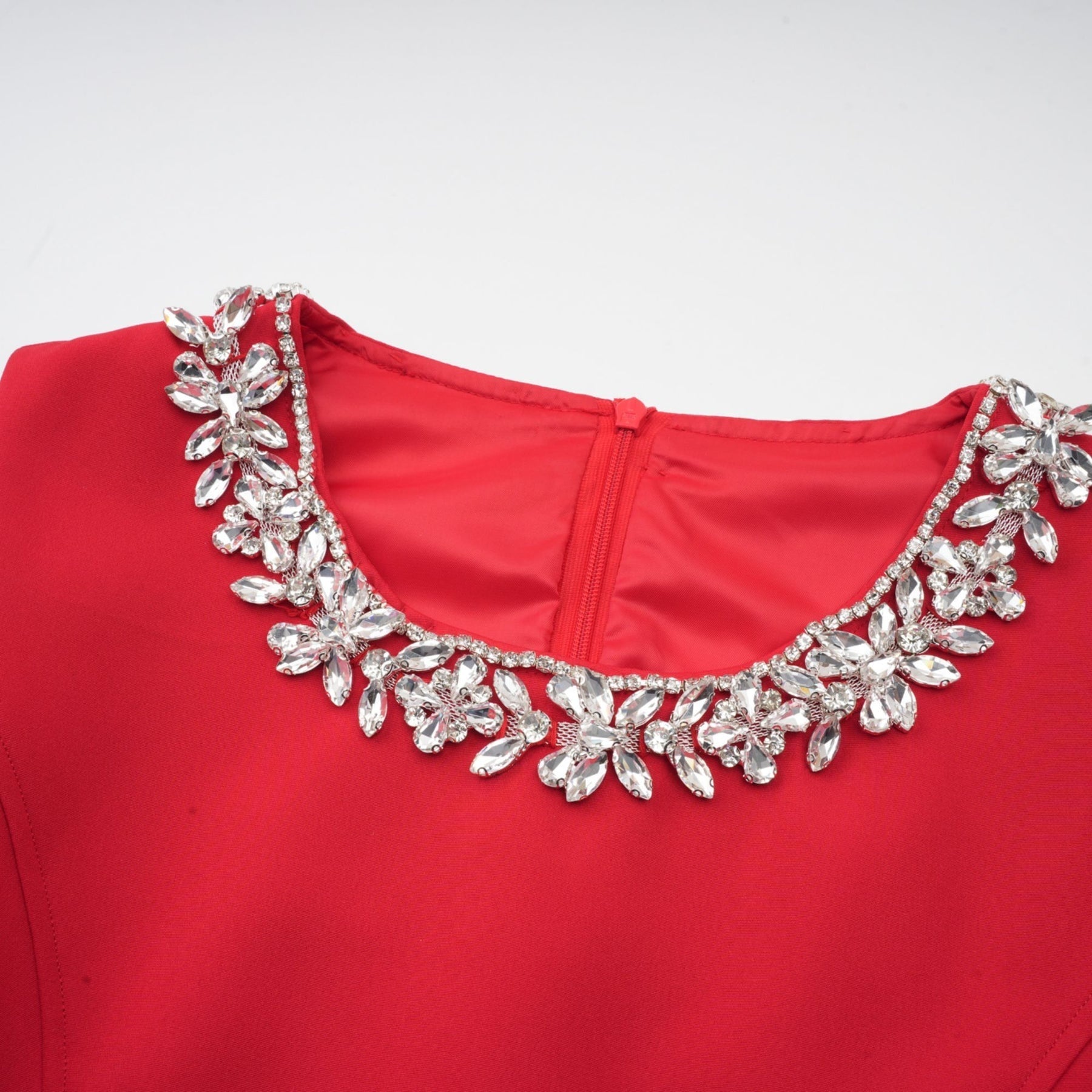A red mini dress with pleats and embellishments named Leonie