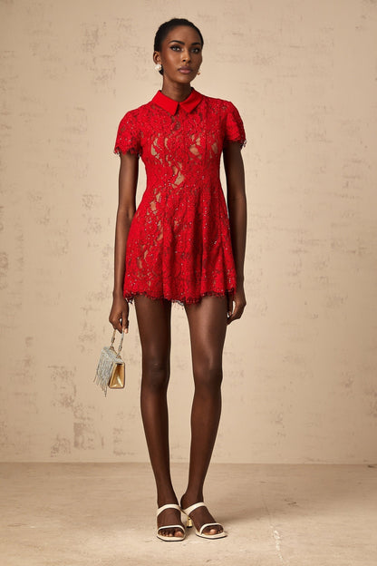 A red mini dress with sequined lace details featuring a short hemline and shimmering embellishments