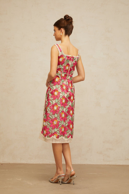 A rosepink midi dress with braided details and floral embroidery featuring a fitted bodice and flowy skirt