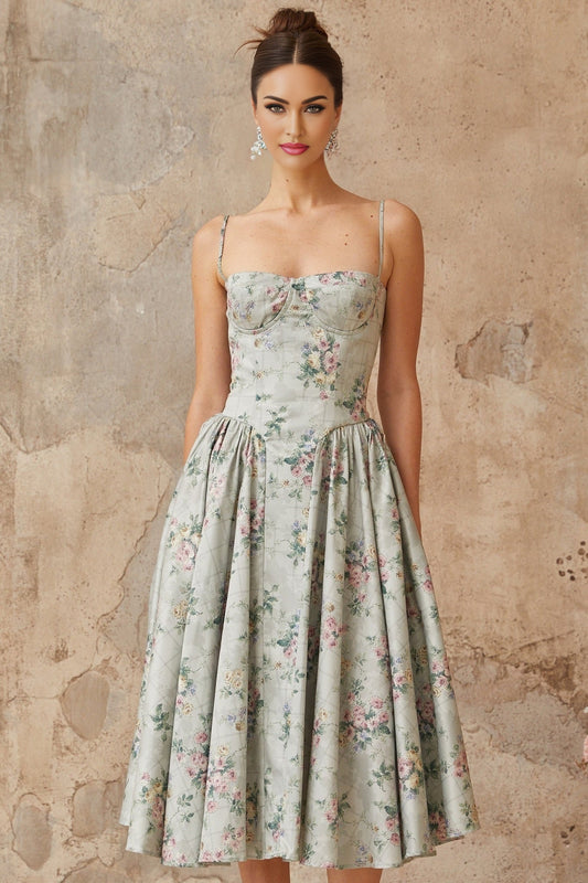 A sagegreen midi dress with a floral print pattern featuring shirred detailing and a feminine silhouette