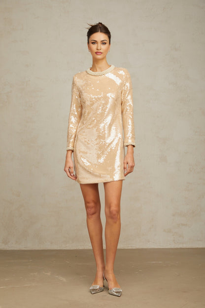 A short beige mini dress adorned with faux pearls and sequins in neutral tones featuring a sleeveless design and form fitting silhouette