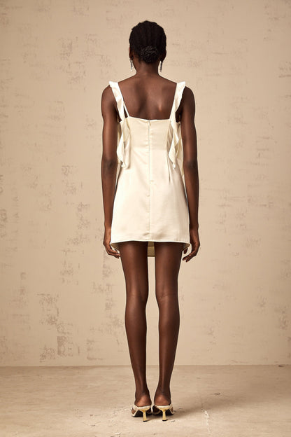 A short beige mini dress with butterfly prints and draped fabric details featuring a sleeveless design and a flowing silhouette