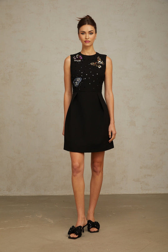 A short black dress adorned with sequins featuring a butterfly design and a mini length silhouette