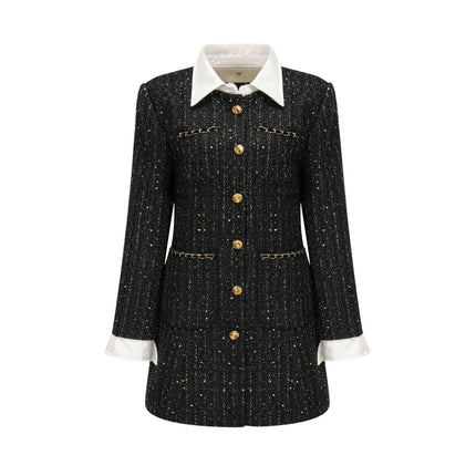 A short black dress with a tweed fabric base and sequin panels featuring a mini length and likely inspired by Audrey Hepburn style