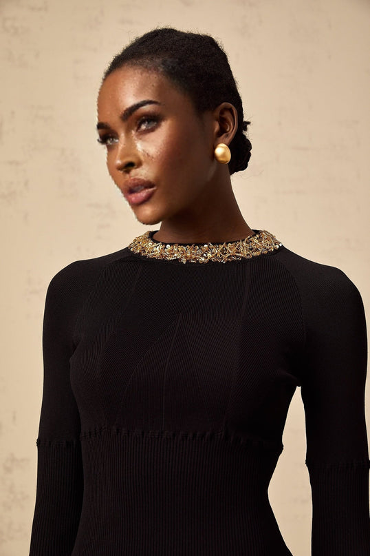 A short black dress with sequin embellishments and a ribbed knit texture featuring a mini length and formfitting silhouette