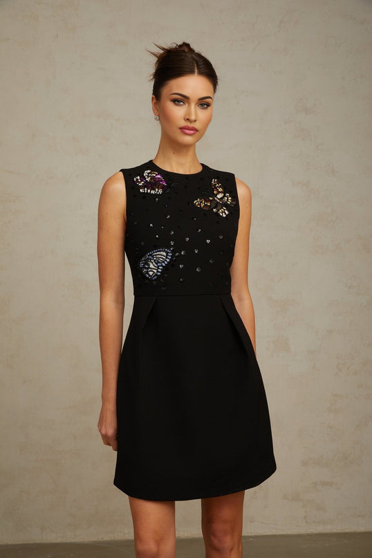 A short black mini dress adorned with sequins featuring a butterfly design