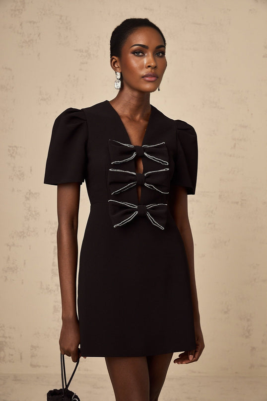 A short black mini dress with a decorative bowknot detail