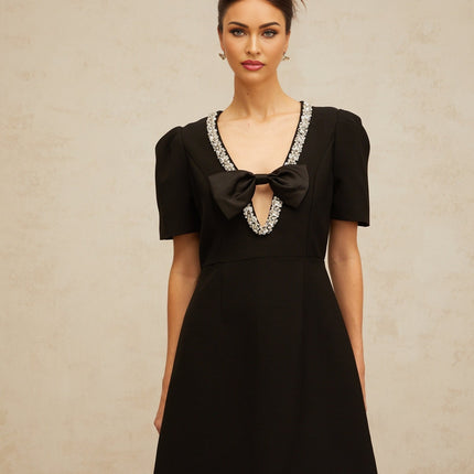 A short black mini dress with a prominent bow embellishment