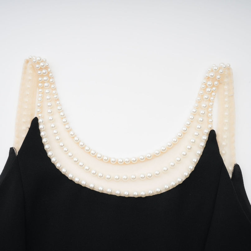 A short black mini dress with faux pearl embellishments named Danae