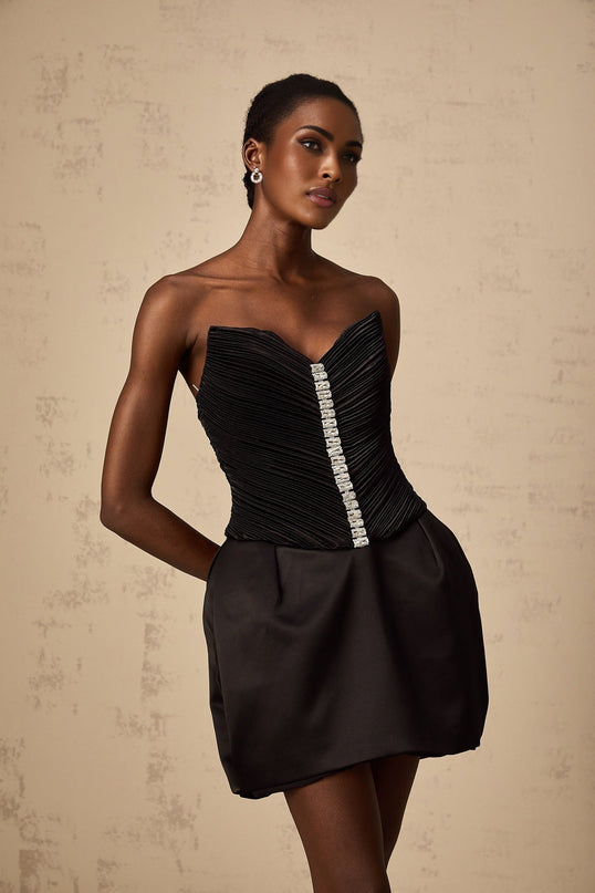 A short black mini dress with ruched detailing and puff sleeves called the Francis dress