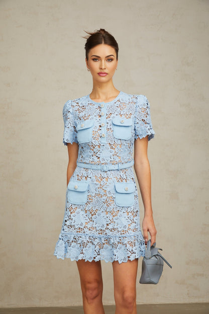 A short blue lace dress with ruffled details and floral appliques adorning the fabric