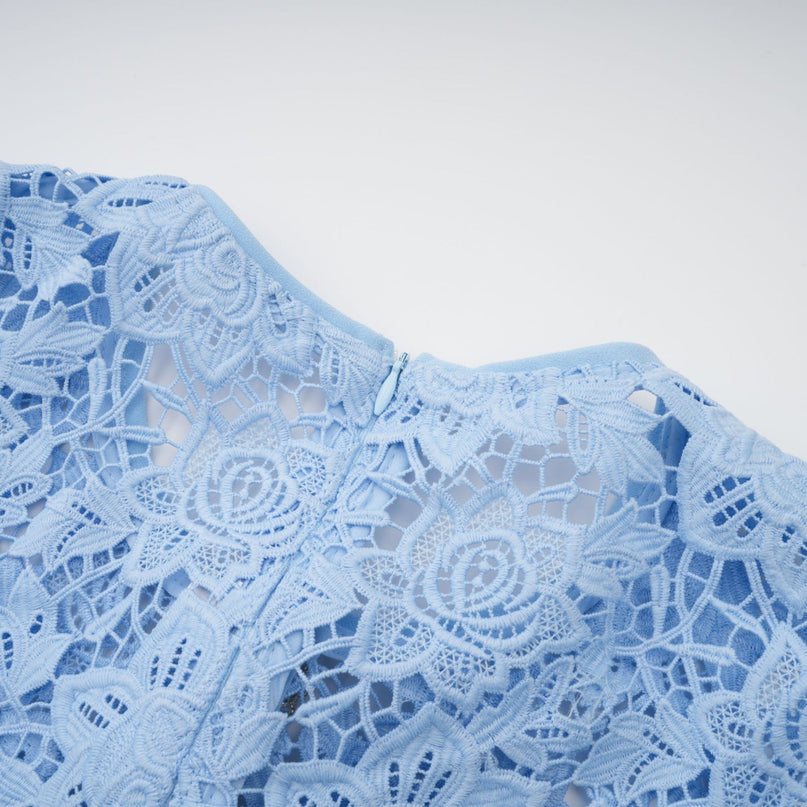 A short blue lace mini dress with ruffled details and floral applique decorations