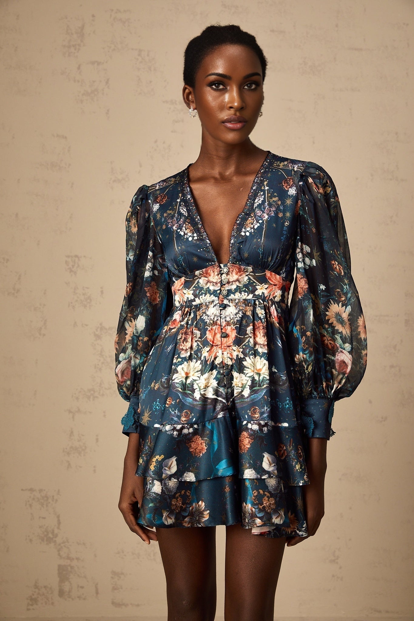 A short blue mini dress with a graphic print pattern and embellishments worn by a model named Candice