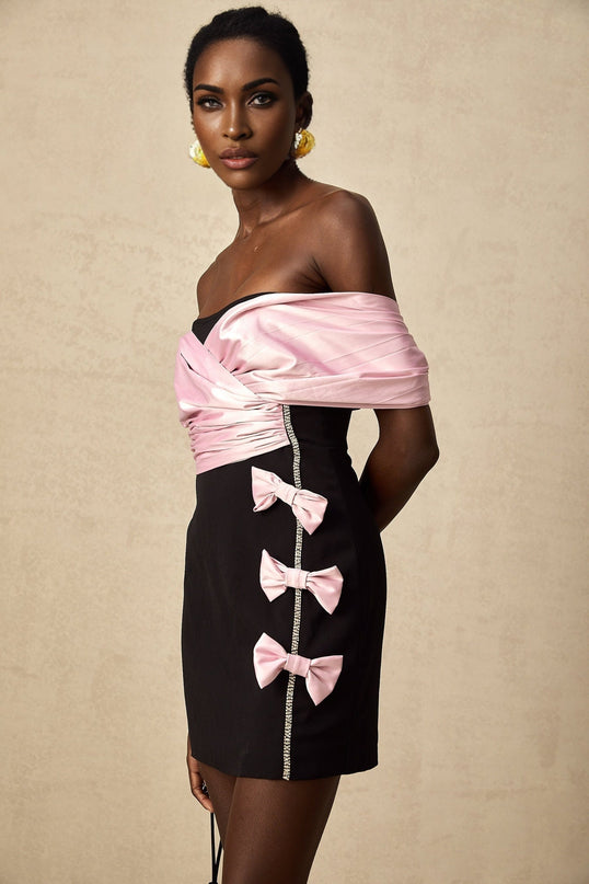 A short colorblocked mini dress with a bow embellishment featuring contrasting colors and a feminine silhouette