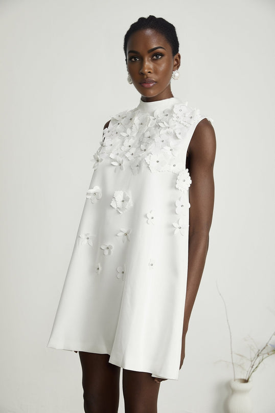 A short floral print dress with a fitted bodice and flared skirt featuring a colorful floral pattern on a light background