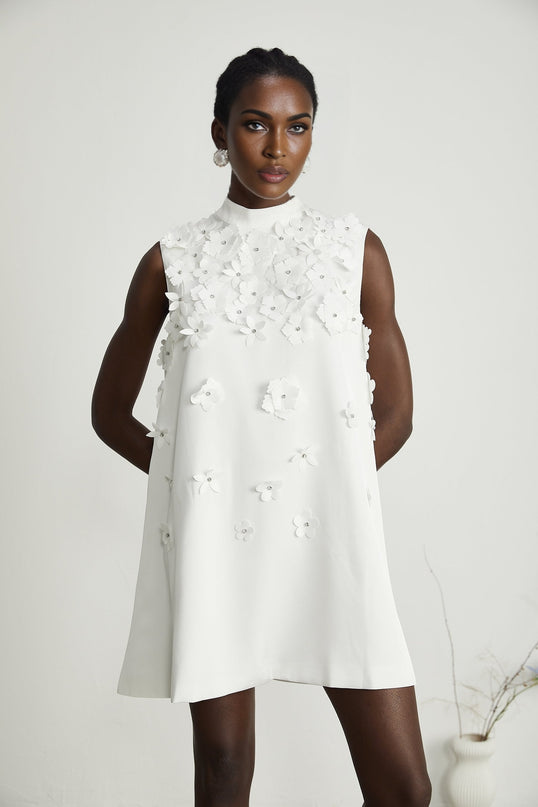 A short floral print dress with a mini length featuring a pattern of small faux flowers on a light background