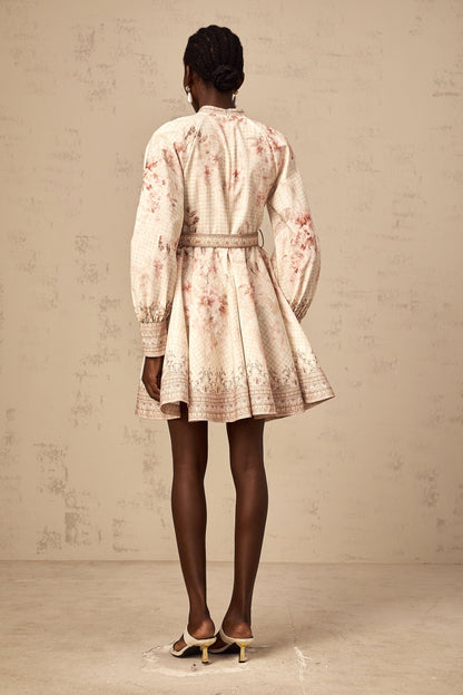 A short floral print mini dress with a belt cinching the waist featuring a vibrant pattern and feminine silhouette