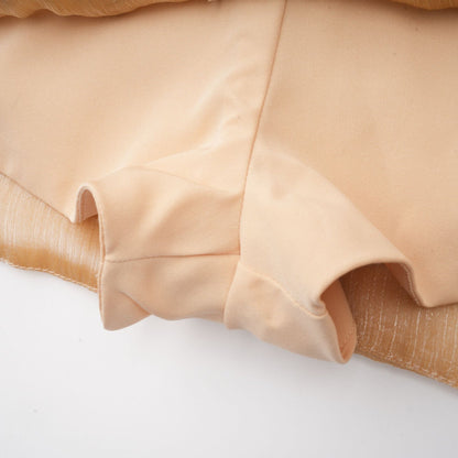 A short gold mini dress with crystal embellishments and paneled design featuring a sleeveless silhouette and formfitting shape