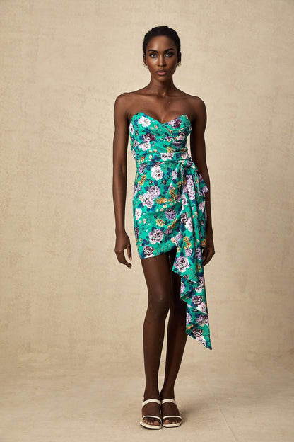 A short green dress with a floral pattern and ruched details featuring a mini length design called the Abby dress