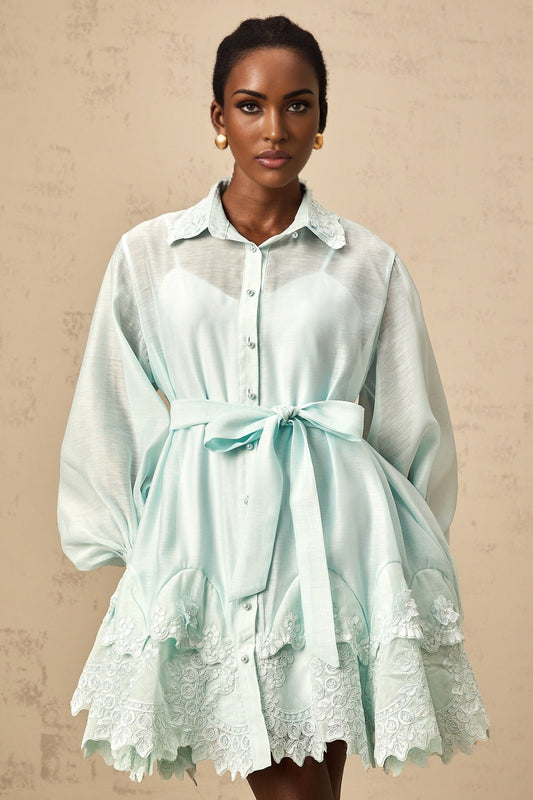 A short green mini dress with lace panel details and a shirtstyle design featuring a collar and buttons