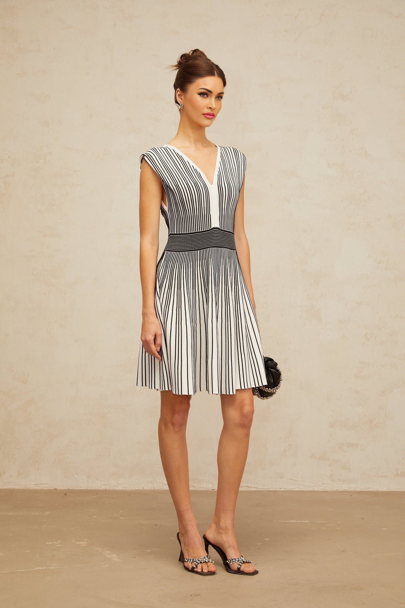 A short knit mini dress with vertical stripes in contrasting colors featuring a design by Joelle