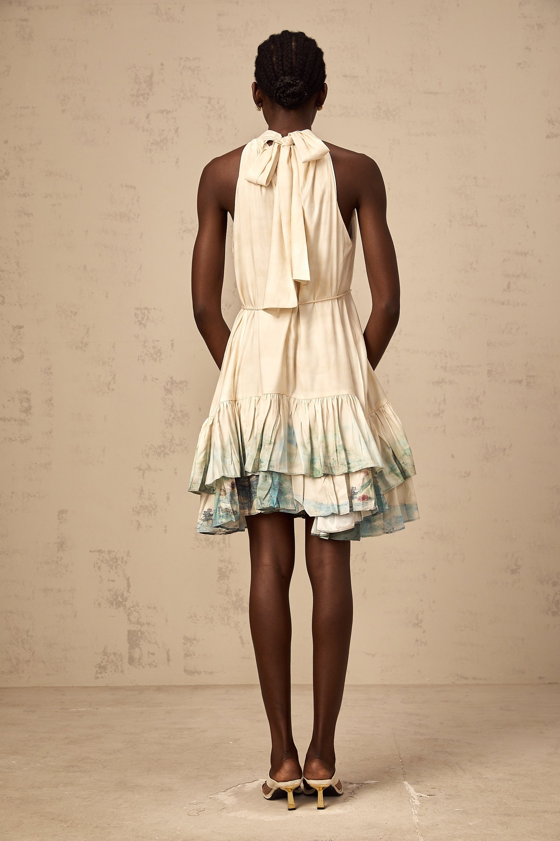 A short layered mini dress with a mixed pattern print featuring different floral and geometric designs in multiple colors