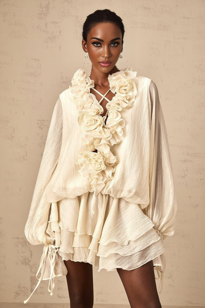 A short light colored tiered mini dress with floral applique details called Zephyrine