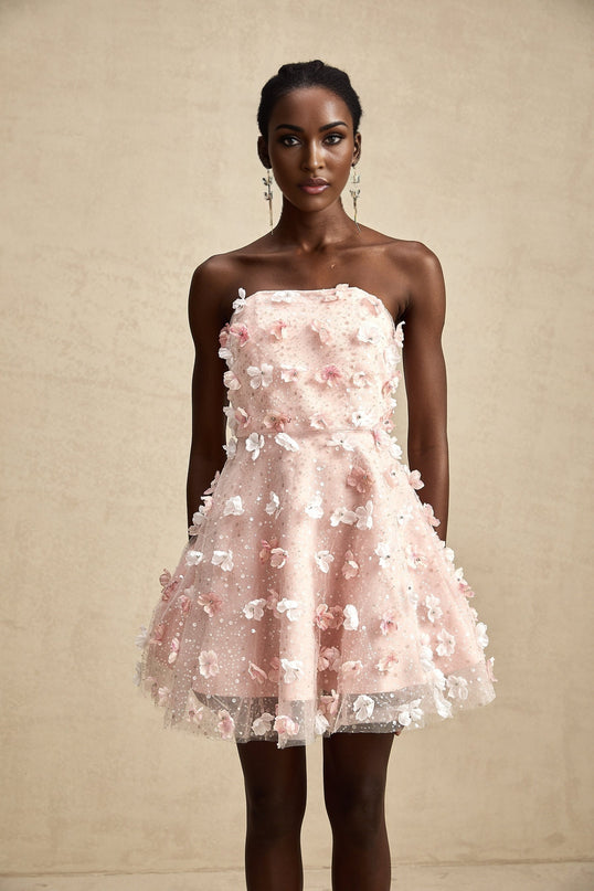 A short mini dress with a puffy silhouette featuring three dimensional petal details covering the entire garment creating a floral textured appearance