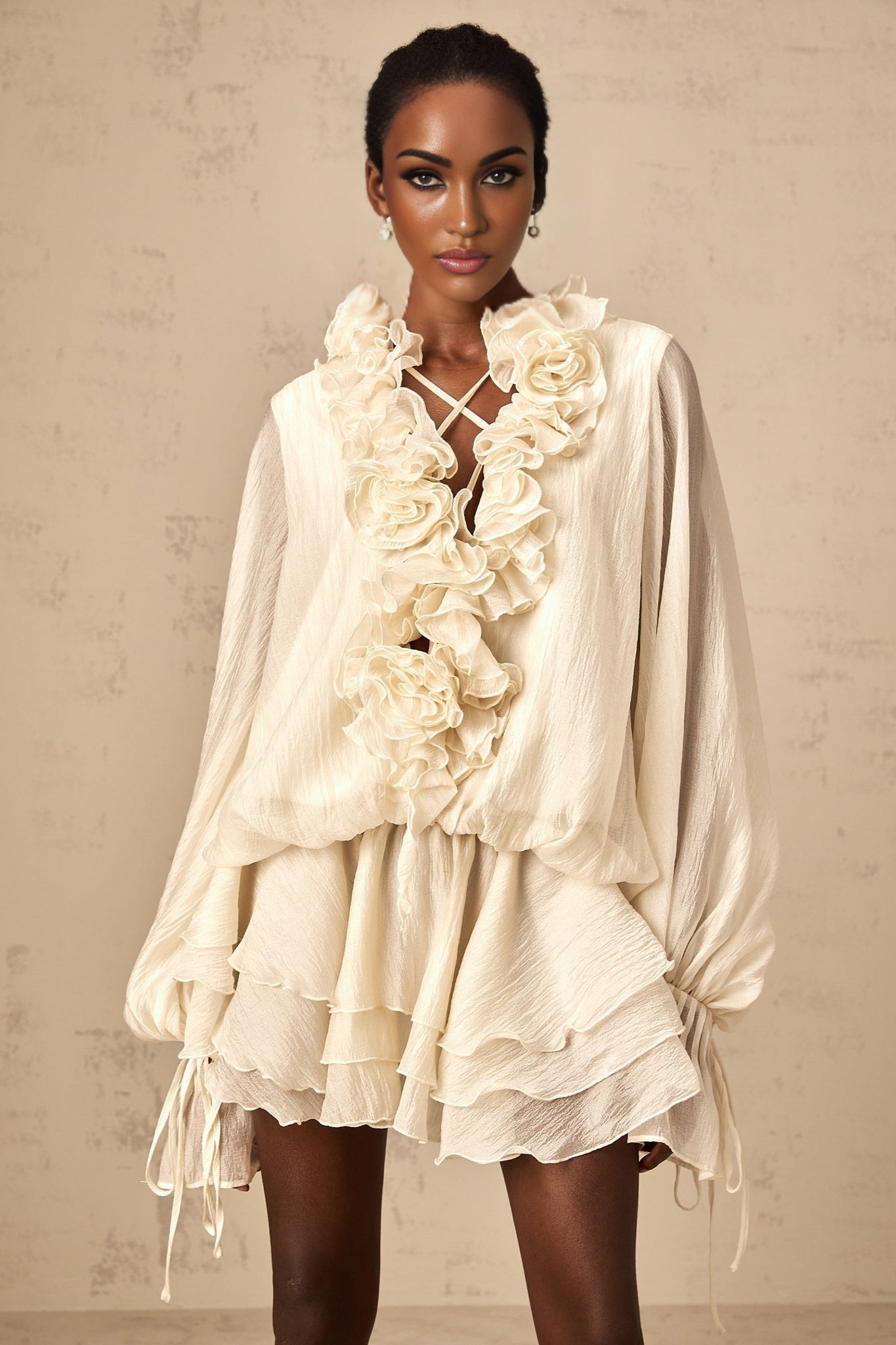 A short neutral colored mini dress with tiered layers and floral applique details named Zephyrine