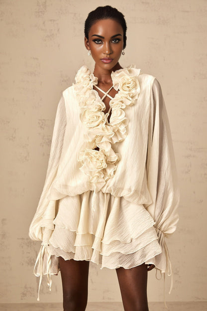 A short neutral colored mini dress with tiered layers and floral applique details named Zephyrine