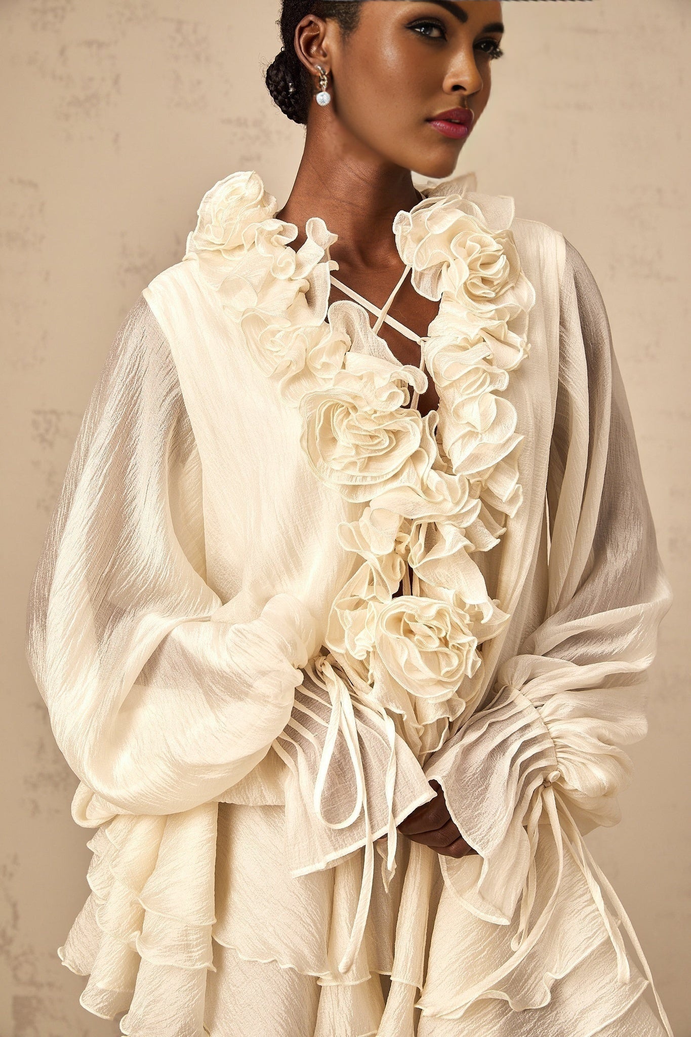 A short neutral colored mini dress with tiered skirt and floral applique details named Zephyrine