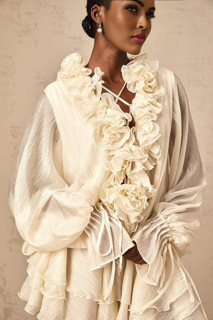 A short neutral colored mini dress with tiered skirt and floral applique details named Zephyrine