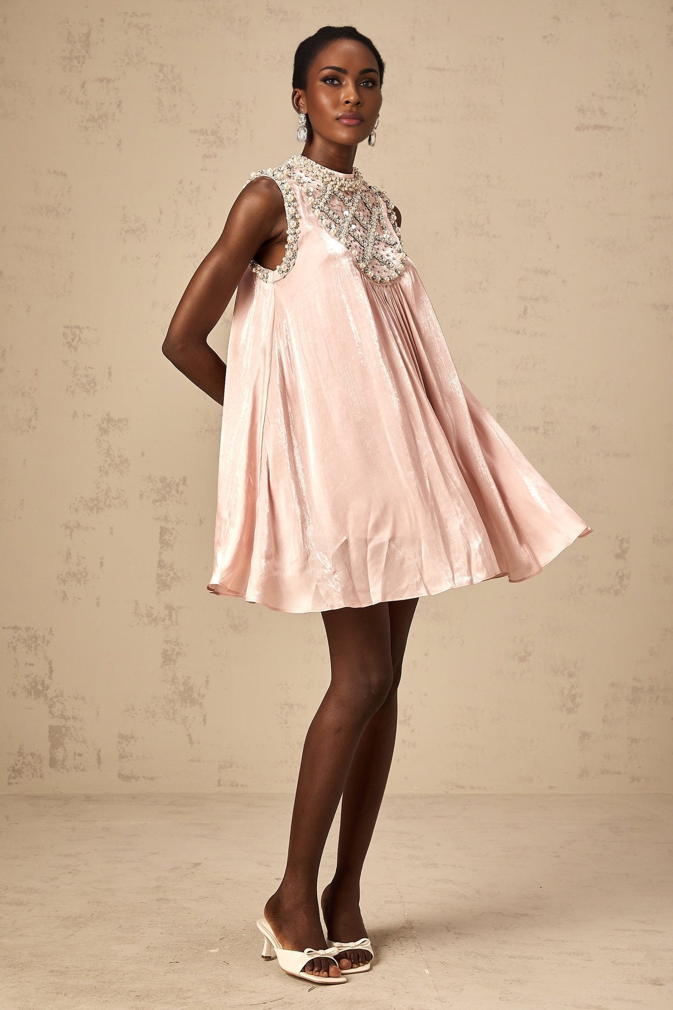 A short pink dress with pleated skirt and embellished details named Helena