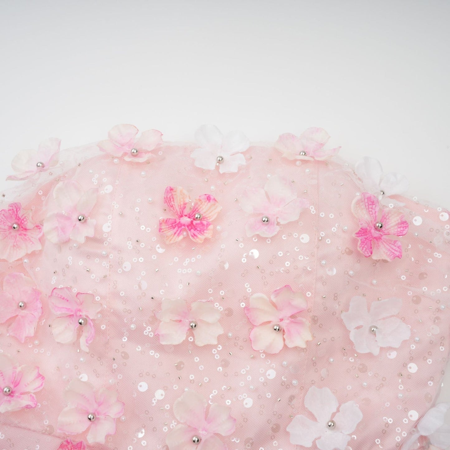 A short pink mini dress with puffy threedimensional floral petal details covering the entire garment creating a textured and voluminous appearance