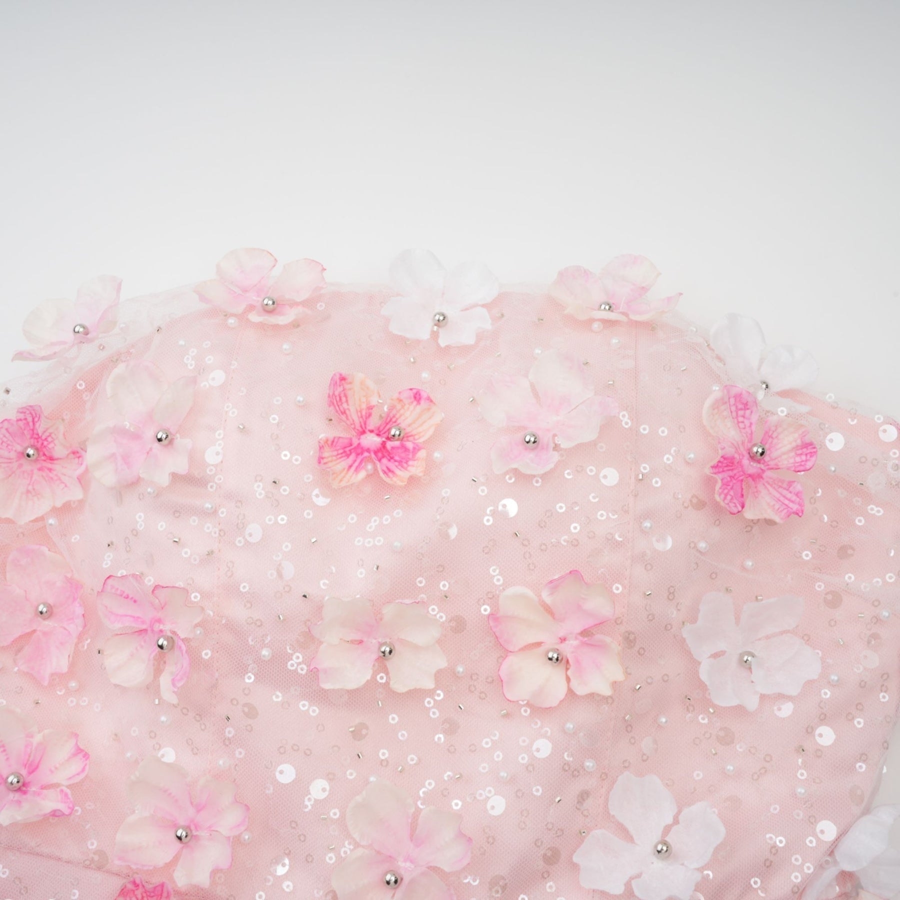 A short pink mini dress with puffy threedimensional floral petal details covering the entire garment creating a textured and voluminous appearance
