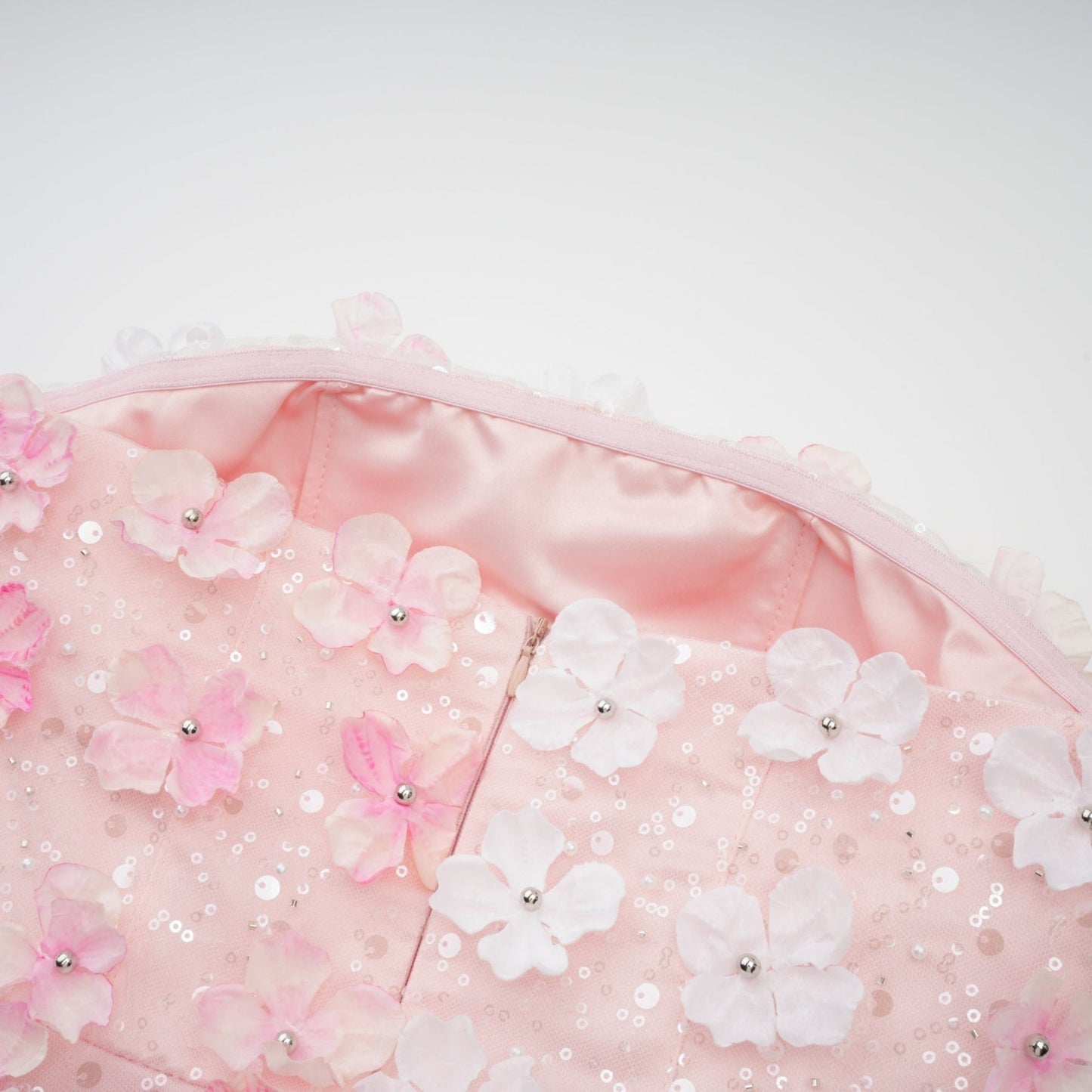 A short pink mini dress with puffy threedimensional petal details covering the bodice and skirt creating a floral textured appearance