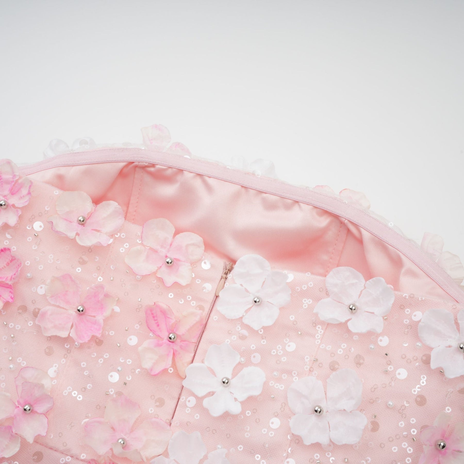 A short pink mini dress with puffy threedimensional petal details covering the bodice and skirt creating a floral textured appearance