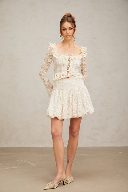 A short pleated mini skirt with shimmering sequins covering the fabric creating a sparkly and festive appearance