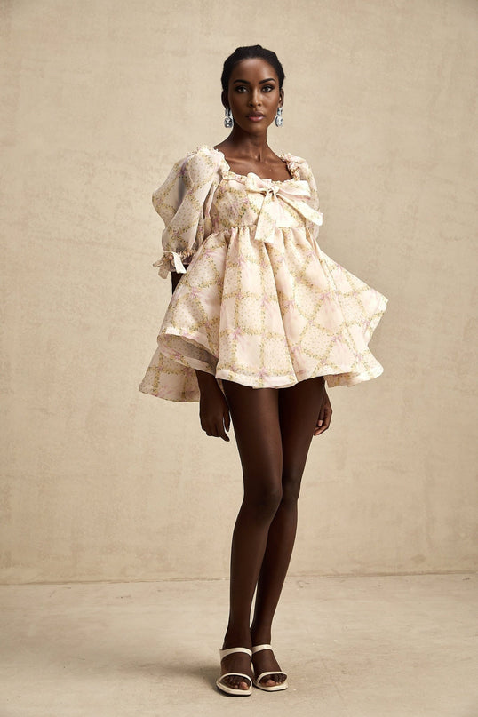 A short puffy mini dress with a check pattern featuring a large bow detail and Lou branding