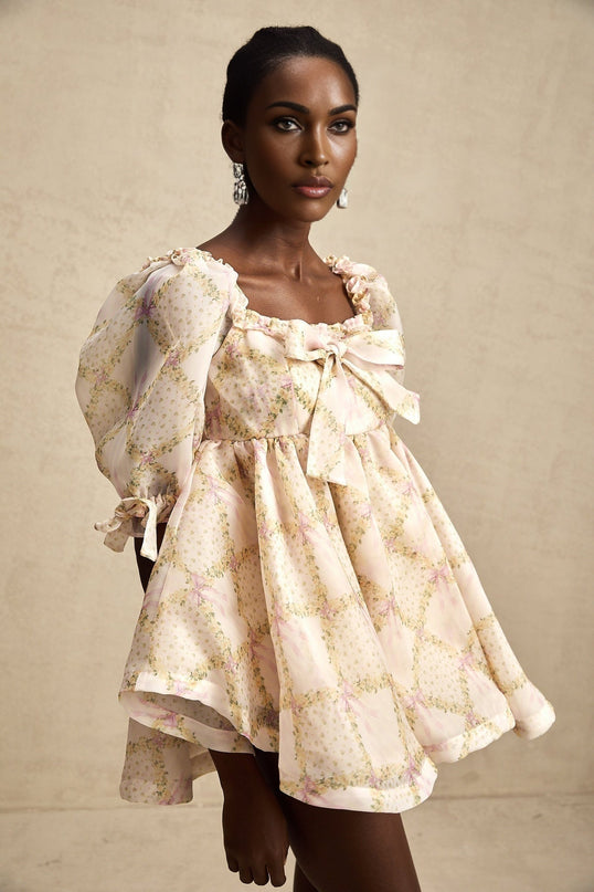 A short puffy mini dress with a check pattern featuring a large bowknot detail in a Lou design