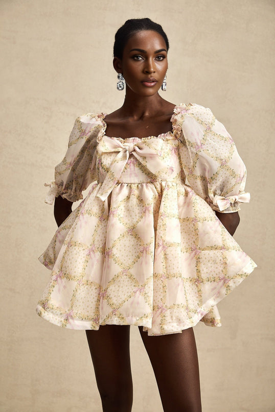 A short puffy mini dress with a check pattern featuring a prominent bowknot detail in a style inspired by Lou designs