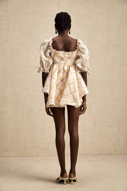 A short puffy mini dress with a checkered pattern featuring a large bow detail at the front in a Lou style design