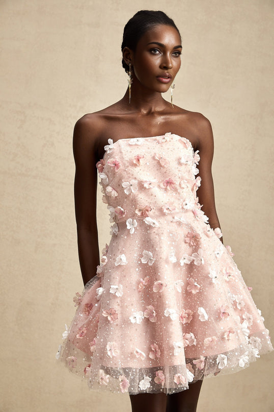 A short puffy mini dress with three dimensional floral petal details covering the fabric creating a textured and voluminous appearance