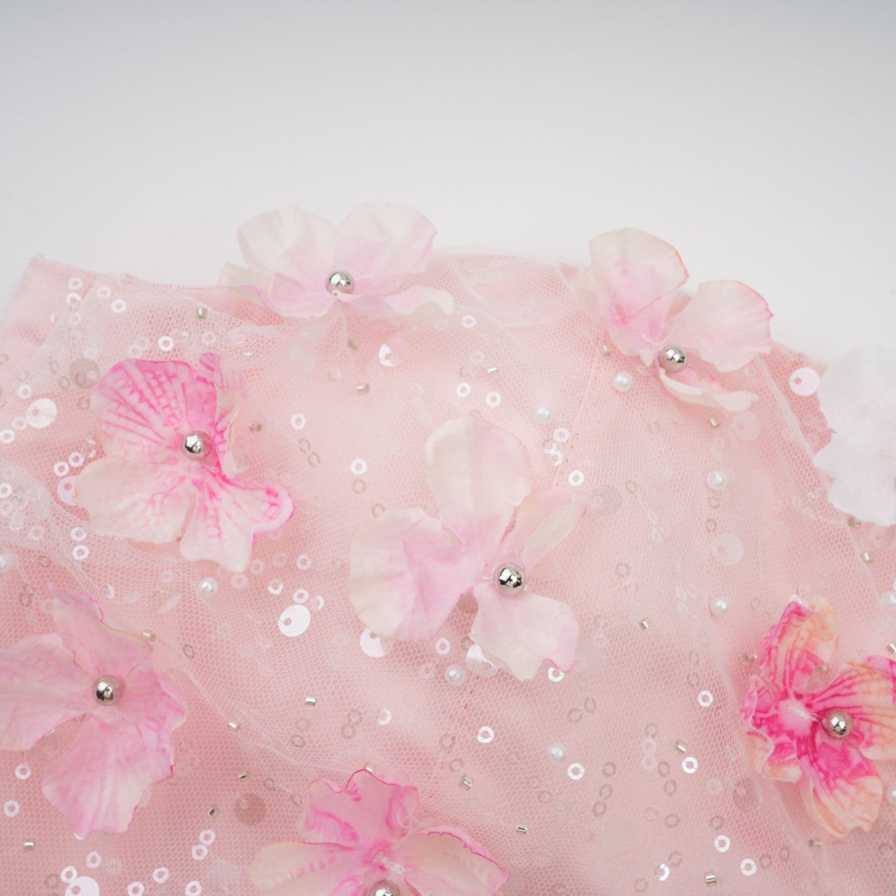 A short puffy mini dress with three dimensional floral petal details covering the fabric creating a textured and voluminous appearance
