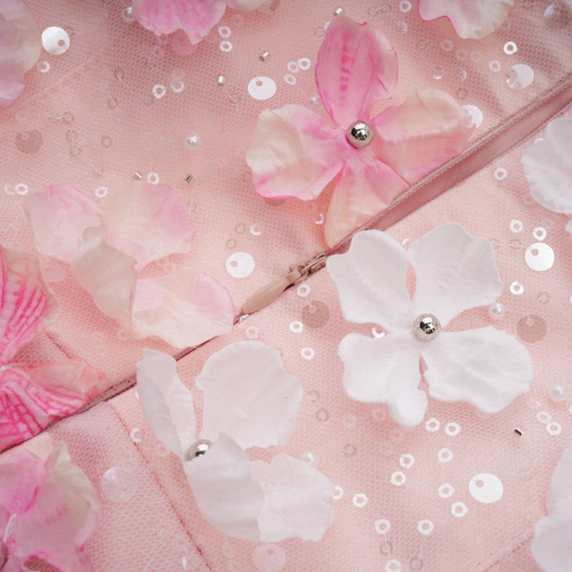 A short puffy mini dress with three dimensional petal details covering the fabric creating a textured floral appearance